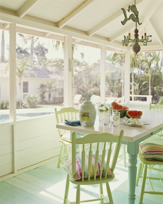 a pretty pastel cottage sunroom with pastel furniture, colorful textiles, a vintage chandelier and much sunshine is lovely