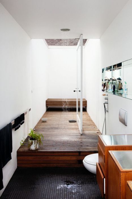 a raised wooden platform defines the shower space and a matching bench adds to the space