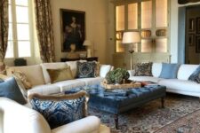 a refined and chic Provence living room with neutral furniture, a crystal chandelier, printed textiles and a beautiful artwork