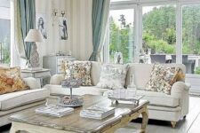 a refined vintage living room with chic neutral furniture, a low coffee table, striped walls and two color curtains plus floral pillows