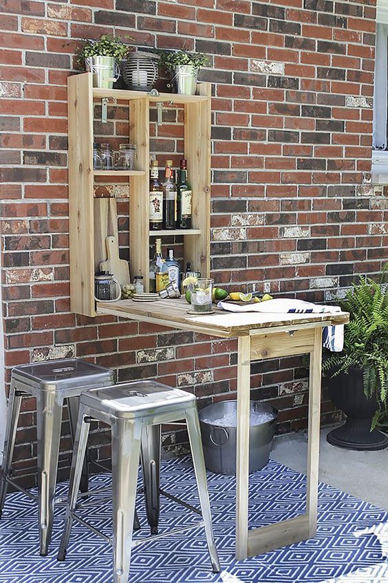 a rustic outdoor bar styled as a Murphy table is a geat idea for a small outdoor space to refresh yourself