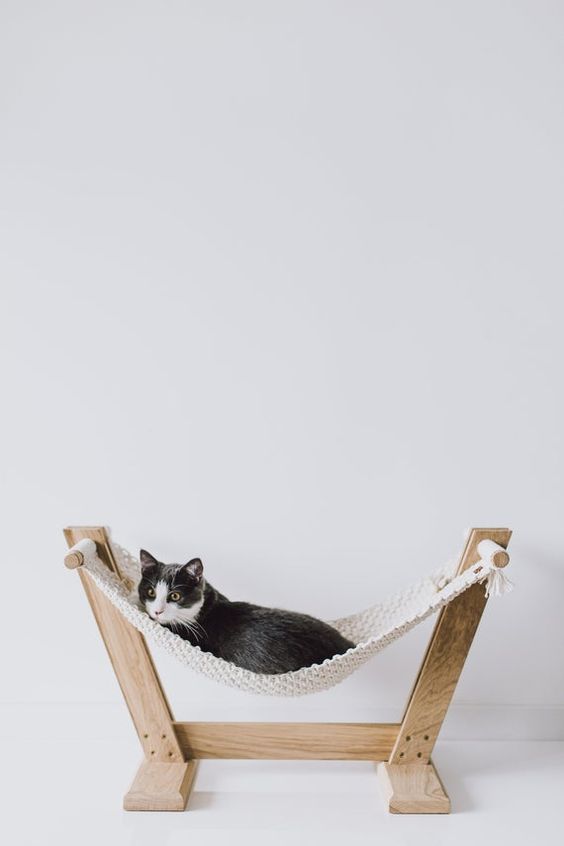 a simple hammock with wooden stands and a crochet hammock is a cool idea for a space with a boho feel