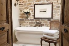 a cozy small bathroom with a stone accent wall