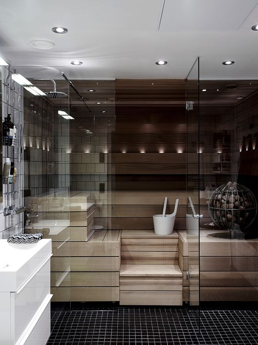 a small and chic wood clad sauna with benches and built in lights and with smoke glass walls