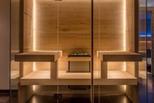 a stylish modern wood clad sauna with built-in lights and benches is very inviting and cool