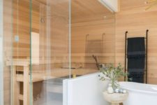 a tiny built-in steam room clad with wood and with a large bench is very cozy and relaxing