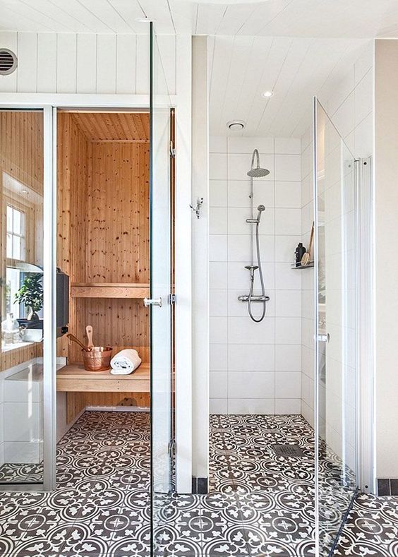 a tiny home sauna clad with light stained wood, with a window, mosaic tiles and floating benches