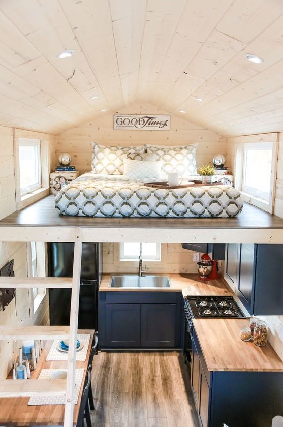 a tiny modern farmhouse home with a kitchen and living room below and a small loft sleeping space is amazing