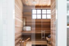 a tiny steam room with windows, a couple of long benches and some additional accessories is chic