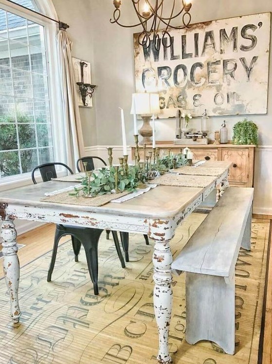 a vintage farmhouse dining space with a large sign, a wooden buffet, a shabby chic table and whitewashed bench