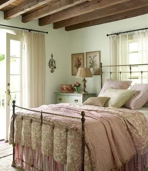 a vintage meets farmhouse bedroom with mint walls, wooden beams on the ceiling and floral print bedding