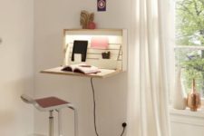 a wall-mounted foldable mini desk with built-in lights and with books and other necessary stuff