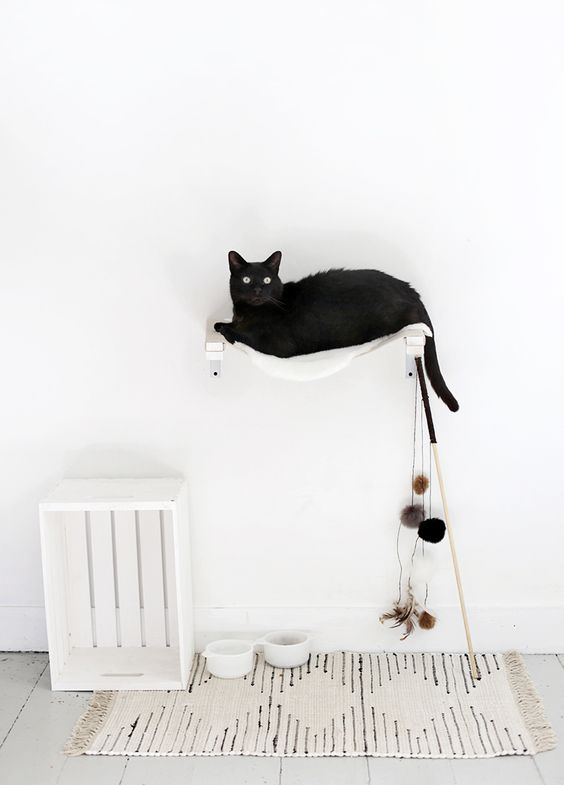 a white wall-mounted hammock bed with toys attached is ideal for a Nordic space
