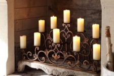 a wrought candle stand with vignettes right in the fireplace is a refined idea to try