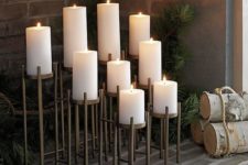 an architectural candelabra for nine pillar candles on graduated risers on long lean legs