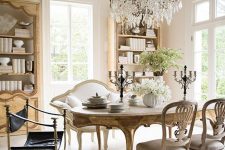 an exquisite vintage dining room with chic buffets, a vintage dining table and vintage chairs, a loveseat and a statement crystal chandelier