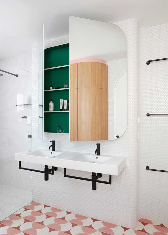a built-in storage space covered with curved mirror doors is a cool and stylish solution for a modern bathroom