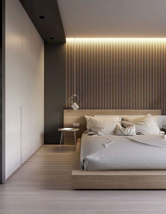a chic minimal bedroom with a wooden bed, a wooden slabs, built in lights, sleek storage space and sconces