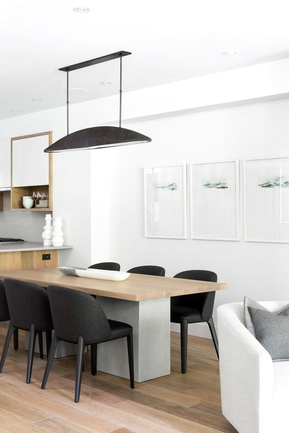 غرف طعام لعشاق الاناقة والبساطة A-chic-minimalist-dining-space-with-a-concrete-and-wood-table-black-chairs-a-black-pendant-lamp-and-a-minimalist-gallery-wall