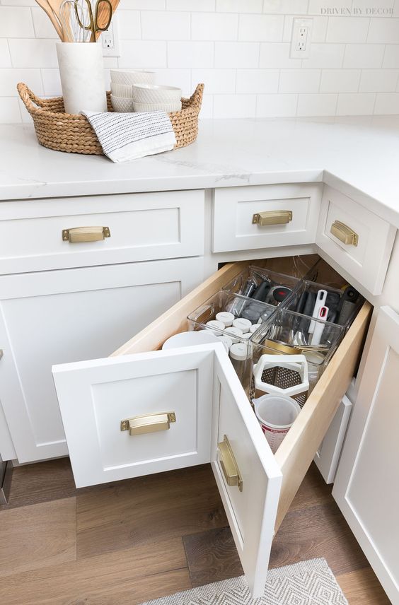 a corner drawer with gold handles is a cool idea to make the use of corner storage space, it's a cool idea to get more storage from deep cabinets