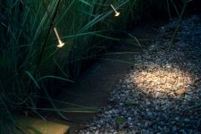 a garden with super delicate and lovely spotlights that illuminate the path but not too much, in a gentle way