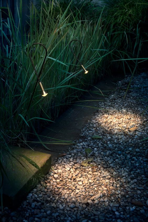 a garden with super delicate and lovely spotlights that illuminate the path but not too much, in a gentle way