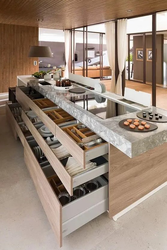 a large stained kitchen island with a stone countertop and lots of drawers for storage is a smart solution for a modern kitchen