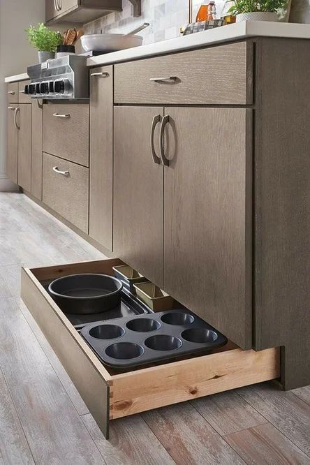 a low drawer under the cabinet is perfect for storing pans, forms and trays is a cool idea for any space