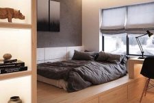 a minimalist bedroom with a platform bed with storage, lit up niches for storage, a built-in desk and a black chair