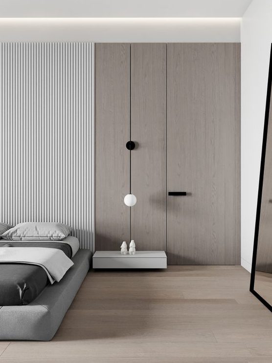 a minimalist bedroom with a plywood and wood slab wall, a grey upholstered bed, a white floatign nightstand and some lamps