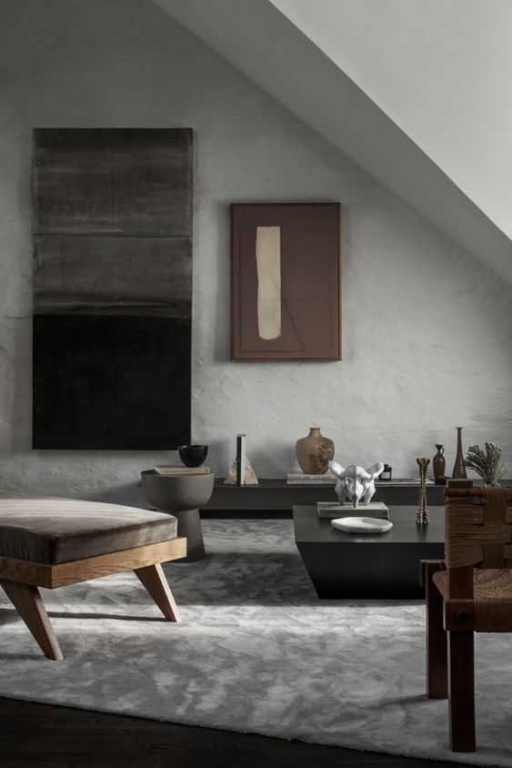 a minimalist living room with a wabi sabi feel, with a stone floor and concrete walls, minimal furniture and artworks