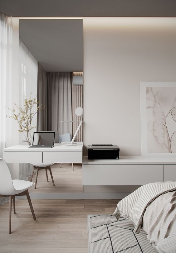 a minimalist neutral bedroom with a floating desk and a mirror, a floating storage unit, a bed with neutral bedding