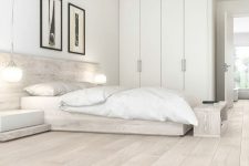 a neutral minimalist bedroom with a floor that matches the furniture, white bedding, a white wardrobe and a couple of artwork