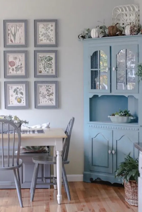a pastel Provence dining space with a blue corner buffet, a vintage dining table, lilac chairs and a gallery wall with lilac frames