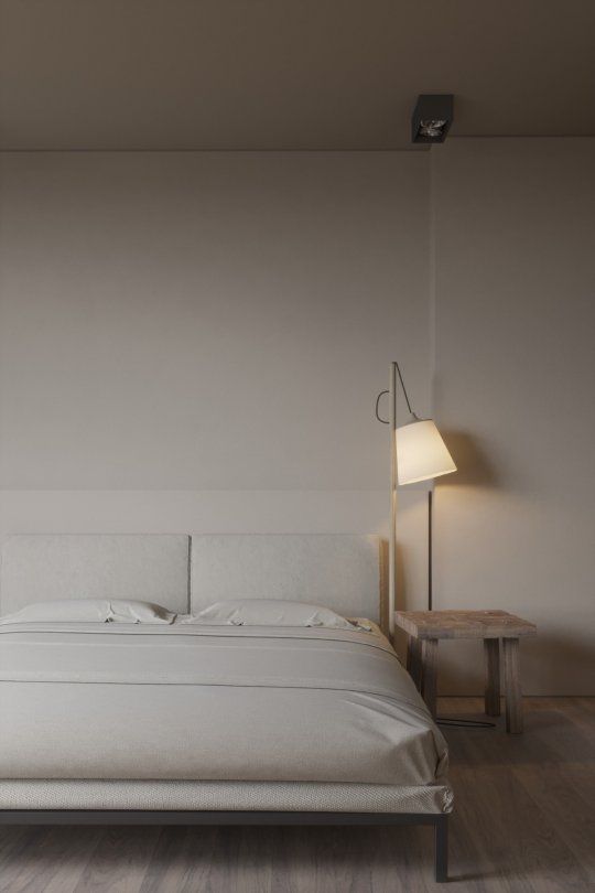 a simple and stylish minimalist bedroom with a creamy bed and bedding, a wooden stool and an elegant lamp is amazing