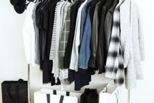 a stylish makeshift closet with shoes stored around and some bags used for storage, too