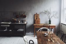 a wabi sabi kitchen with a white plank floor, stained wooden furniture and a metal kitchen island with sinks