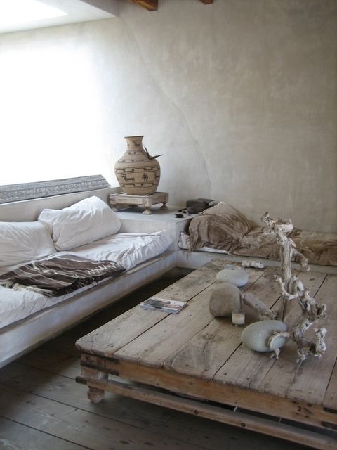 a wabi-sabi living room with brutal wooden furniture, vases, stones and concrete walls