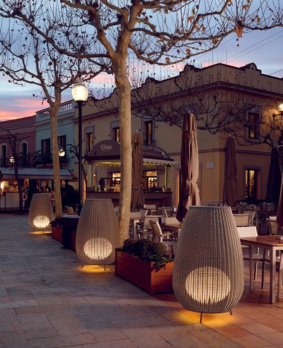 oversized woven amphora lamps on legs bring a cozy indoor feel to the space making it cooler and a bit rustic