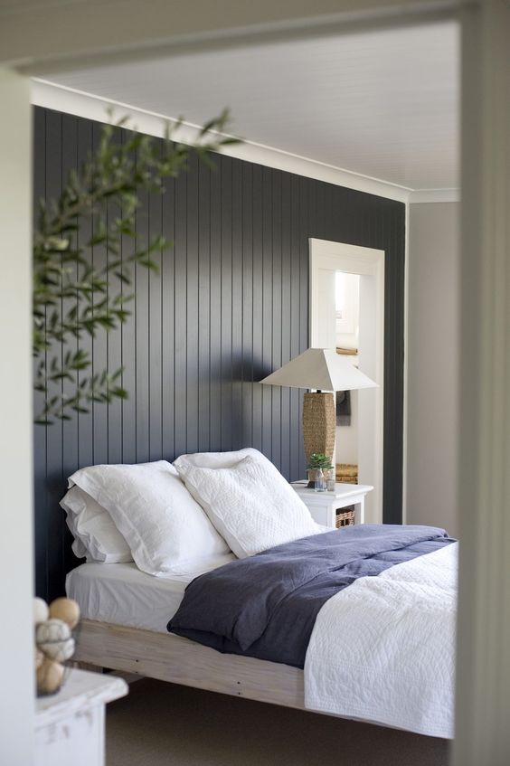 a black shiplap statement wall makes the bedroom more relaxed, cozy and ads a touch of drama with its color