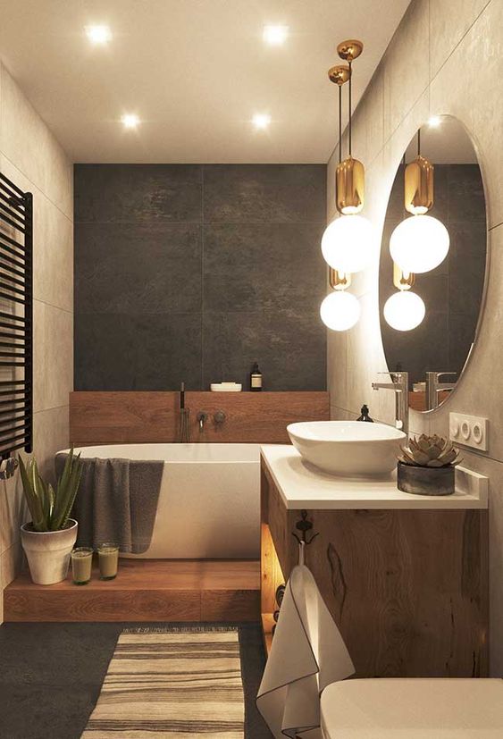 a contemporary bathroom with neutral and graphite grey tiles, on a wooden platform, with a wooden vanity and cool pendant lamps