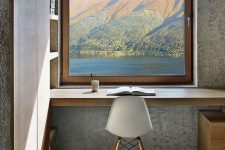 a fantastic home office nook in minimal style, with a window to a lake and mountains, built-in shelves and a built-in desk, a white chair