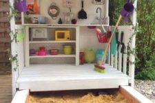 a lovely shed with toy tableware and other stuff, with buntings and greenery plus a sand box is a geat idea