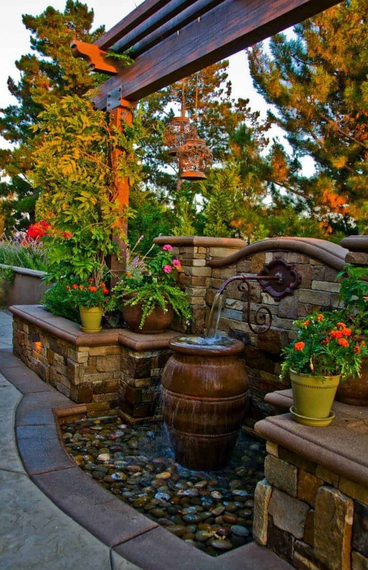 une jolie fontaine d'inspiration vintage issue d'un mur de briques, avec une grande jardinière et des galets au sol sera idéale pour un espace plus formel une jolie fontaine d'inspiration vintage issue d'un mur de briques, avec une grande jardinière et des galets au sol sera idéale pour un espace plus formel