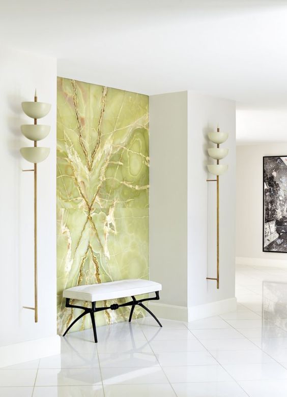 a luxurious white entryway accented with a green onyx statement wall looks really breahttaking