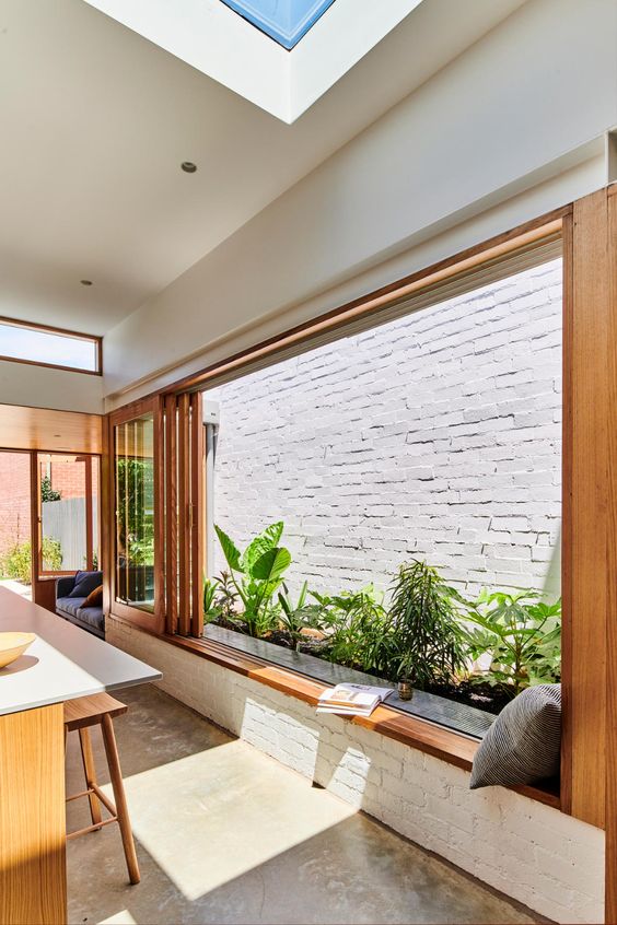 a modern kitchen with a folding window that opens to a private minni garden and features a windowsill seat to have drinks and meals here