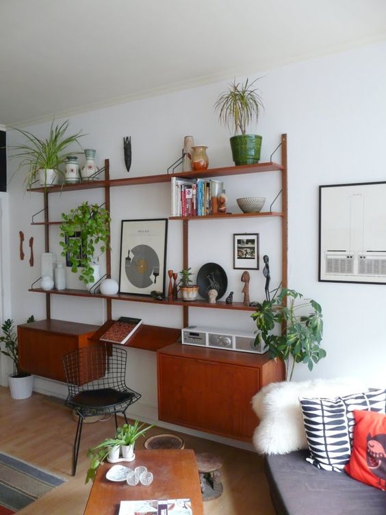 a rich-stained mid-century modern storage unit of shelves and cabinets to display stuff and features a mini desk