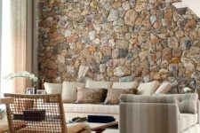 a rough stone accent wall adds a natural feel to the contemporary living room and brings a touch of natural color