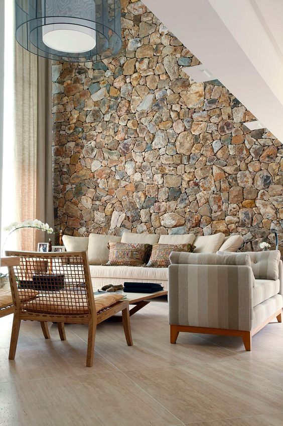 a rough stone accent wall adds a natural feel to the contemporary living room and brings a touch of natural color