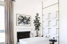 a sophisticated modern bathroom with a fireplace, a rectangular but, a large ladder for towels, a black carved table, a potted plant and blush curtains